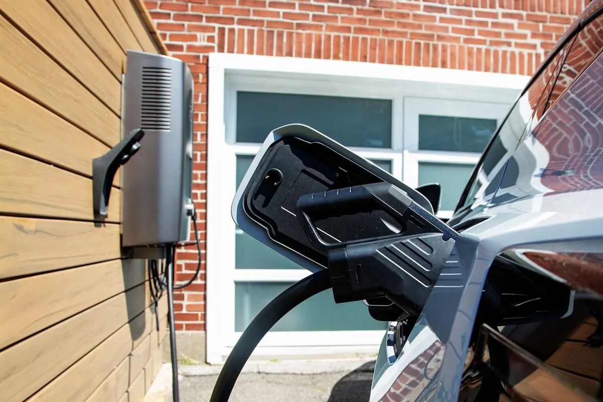 Residential EV charger mounted on garage wall with vehicle plugged in